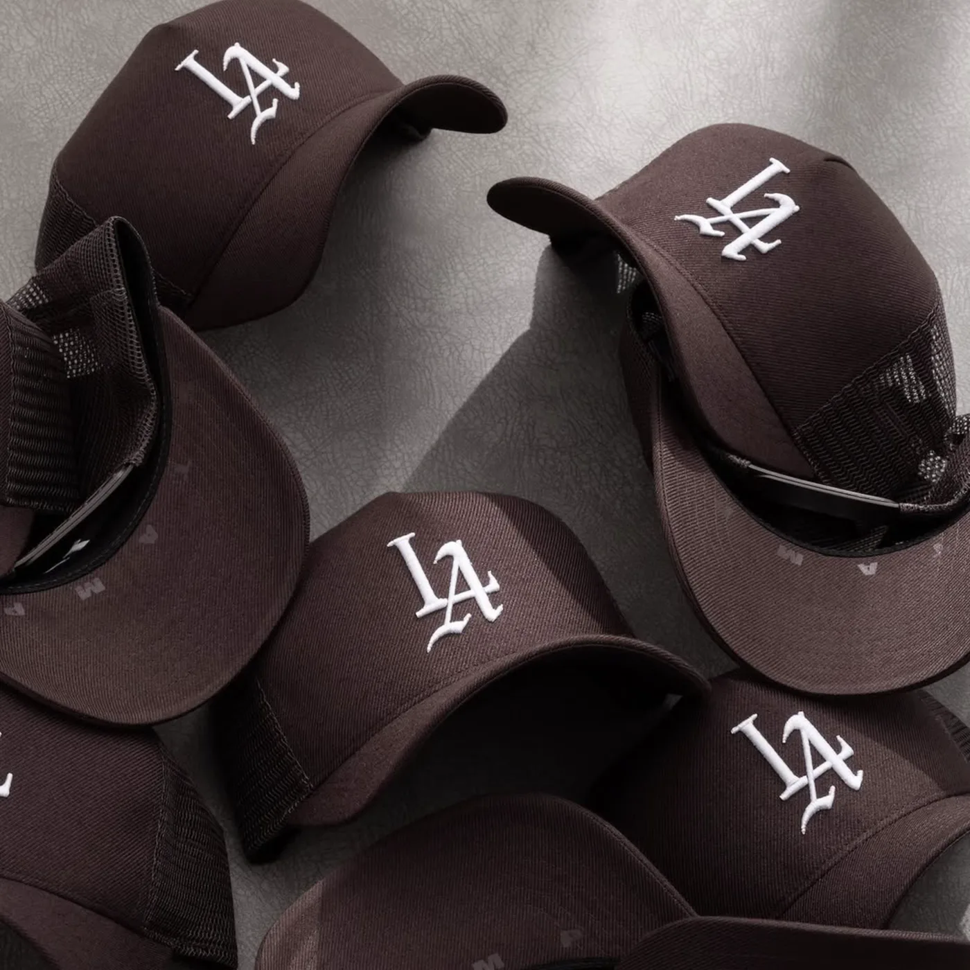 Stack of dark caps with raised white embroidered logos